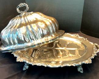 An exquisite early 20th-century silver-plated domed meat server by A.B. Savory & Sons of Sheffield, England, renowned for their fine English silver craftsmanship. This stunning Victorian-style serving piece features ornate Rococo scrollwork handles and feet, a scalloped cloche lid, and a divided footed tray designed for carving and presentation. Perfect for holiday gatherings and elegant dining, this heirloom-quality piece adds a touch of grandeur to your Thanksgiving or Christmas table display. A statement of timeless taste and tradition from one of England's celebrated silversmiths.