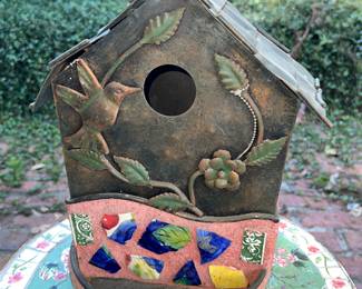 metal birdhouse decorated with a tile mosaic base