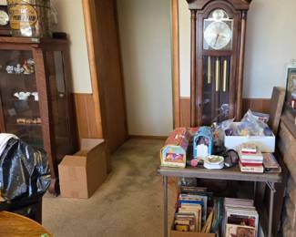 Grandfather clock and a table filled with vintage toys