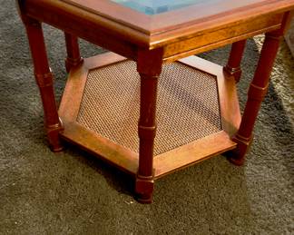 vintage mid-century modern hexagonal walnut side table with a glass top and caned lower shelf.