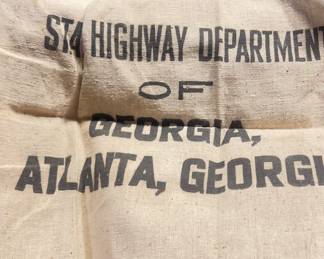 canvas bag with faded black text printed on it. The text identifies the bag's origin and purpose.
State Highway Department OF GEORGIA
ATLANTA, GEORGIA