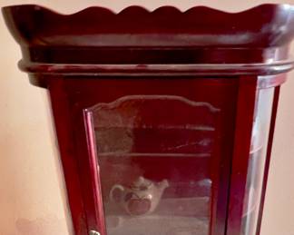 This is a vintage mahogany finish wooden bow front miniature curio cabinet.