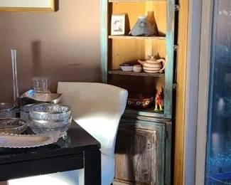 Corner cabinet, white faux snake skin pattern chairs, heavy lacqured black dinning table, tons of crystal and glass, Mexican pottery and decor. 