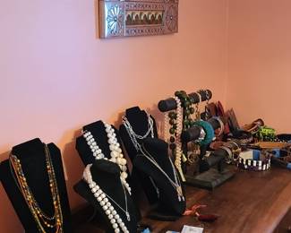 Jewelry and belts. Metal and tile mirror. Wooden dresser. 