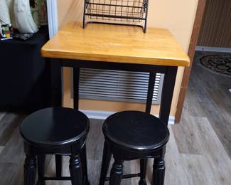 Set of bar height table with 2 black wood stools.