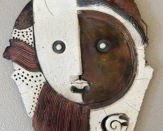 Raku-fired ceramic wall sculpture of an abstract face created by artist Doug DeLind.