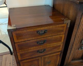 vintage wood campaign-style chest of drawers with brass hardware. 