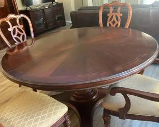 A Large Round Pedestal Table With Leaf And Four Matching Chair Chairs