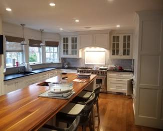 White modern farmhouse kitchen by Quality Custom Cabinetry. Kitchen is U-shaped with a long island. Pendant lights