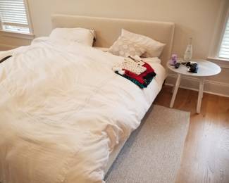 King bed with upholstered headboard; end table