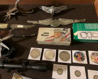 Silver dollars and mercury dimes, coins, Vintage  Solingen Germany Stag Handle Fixed Blade knife and leather sheath, Harley Davidson metal emblems, antique horse spur, rifle scope,  handcuffs new in box, JOHN WAYNE - Winchester 32-40 Collectible Ammo 
