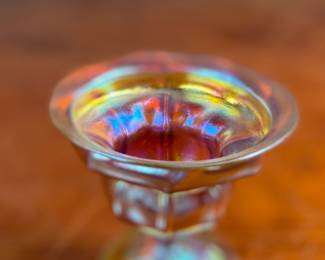 This lot features an iridescent gold Tiffany Favrile sherbet glass with maker marks present underneath as shown in photos. One small repair on the foot ring and measures, 3.5” H x 4” W x 4” D.