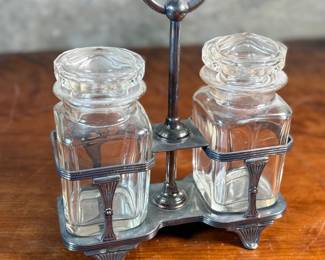 This lot features an antique silver-plated and crystal double pickle castor set, manufactured by Walker & Hall. Maker marks present underneath as shown in photos. Both inserts have minor chipping around the lid. This set measures, 10.25” H x 7.5” W x 4” D.