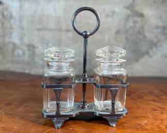 This lot features an antique silver-plated and crystal double pickle castor set, manufactured by Walker & Hall. Maker marks present underneath as shown in photos. Both inserts have minor chipping around the lid. This set measures, 10.25” H x 7.5” W x 4” D.
