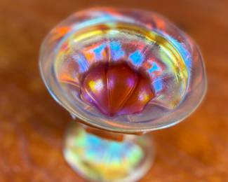 This lot features an iridescent gold Tiffany Favrile sherbet glass with maker marks present underneath as shown in photos. One small repair on the foot ring and measures, 3.5” H x 4” W x 4” D.