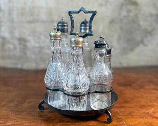 This lot features a Victorian cruet set, manufactured by Wildman’s. Maker marks present underneath as shown in photos. This cruet set measures, 10” H x 7” W x 7” D.
