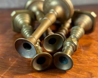 This lot features a collection of six (6) antique brass candlesticks. Three matching pairs with the tallest measuring, 9.5” H.