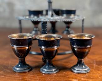 This lot features an antique silver-plated Victorian egg cruet set with six egg cups. This cruet measures, 9” H x 7.5” W x 7.5” D.