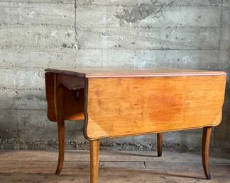 This lot features a 19th century Hepplewhite drop-leaf table in sturdy condition with excellent patina. It measures (closed), 30” H x 28” W x 40” D. When open, it measures, 30” H x 56” W x 40” D.