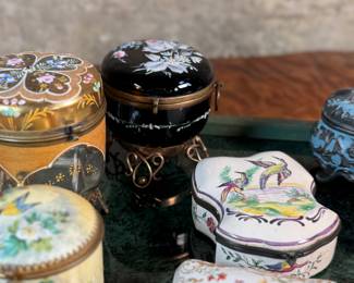 This lot features a large collection of antique trinket boxes that are primarily porcelain. Many of them contain maker marks and are held on a vintage green tray that is included.