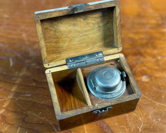 This lot features a collection of inkwells and accessories. One appears to be handmade out of wood and signed underneath by John R Craighead.
