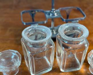 This lot features an antique silver-plated and crystal double pickle castor set, manufactured by Walker & Hall. Maker marks present underneath as shown in photos. Both inserts have minor chipping around the lid. This set measures, 10.25” H x 7.5” W x 4” D.