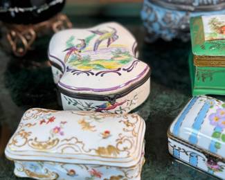 This lot features a large collection of antique trinket boxes that are primarily porcelain. Many of them contain maker marks and are held on a vintage green tray that is included.