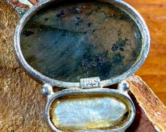 This lot features a stunning studio made pendant, crafted with sterling silver and features numerous stones including Citrine, Peridot, Biwa Pearl, & Labradorite. This pendant measures, 2.5” H and has a total approx. weight of 15.65 grams.