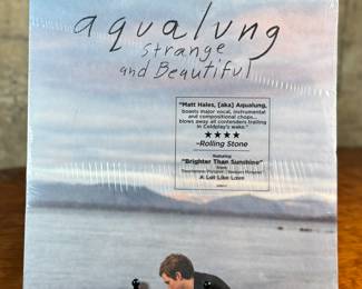 This lot features a sealed vinyl record of the album titled, Strange and Beautiful by Aqualung (Matt Hales). It was released in 2006 and features the popular track, "Brighter Than Sunshine".
