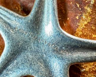 This lot features a sterling silver starfish charm bracelet with an inlay stone by designer, Elsa Peretti for Tiffany & Co. This bracelet measures 7” and has a total approx. weight of 34.32 grams.