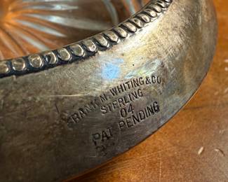 This lot features an antique Victorian silver plated wine coaster trolley made in Japan along with a sterling silver wine coaster by Frank Whiting & Co.