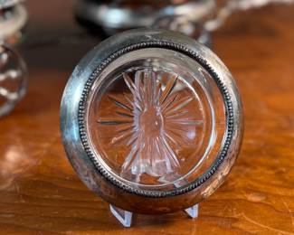 This lot features an antique Victorian silver plated wine coaster trolley made in Japan along with a sterling silver wine coaster by Frank Whiting & Co.