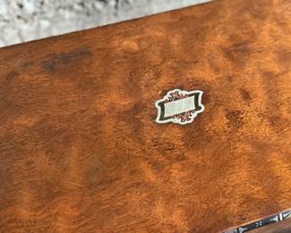 This lot features a 19th century burled walnut writing slope on a lacquered stand. The burled walnut top has a central brass inlaid presentation plaque that is inscribed. This piece measures (on stand), 18” H x 15.5” H x 11” D.