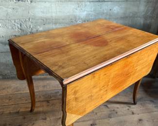 This lot features a 19th century Hepplewhite drop-leaf table in sturdy condition with excellent patina. It measures (closed), 30” H x 28” W x 40” D. When open, it measures, 30” H x 56” W x 40” D.