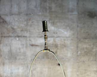 This lot features a mid-century modern sculptural table lamp, made of walnut and brass. Minor wear throughout as shown in photos and light turns on periodically (will need to some servicing or love). This lamp measures, 38” H x 7” W x 7” D.