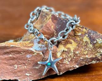 This lot features a sterling silver starfish charm bracelet with an inlay stone by designer, Elsa Peretti for Tiffany & Co. This bracelet measures 7” and has a total approx. weight of 34.32 grams.