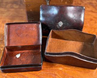 This lot features a collection of boxes from the 19th and 20th century. The two smaller ones up top are crafted from leather, the two below from wood, and the one in front is metal.