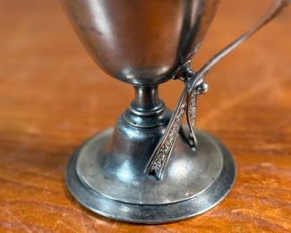 This lot features a 1873 birth commemorative sterling silver footed cup retailed by Ohio jeweler & silversmith, William Wilson McGrew (1833-1893). This silver cup was made to commemorate the birth of Nathaniel Foster Wilshire, son of George Wilshire who was a railroad and business tycoon. This cup measures, 5.25” H x 2.75” W x 4” D with a total approx. weight of 176.61 grams. Maker marks present underneath as shown in photos.