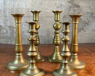 This lot features a collection of six (6) antique brass candlesticks. Three matching pairs with the tallest measuring, 9.5” H.