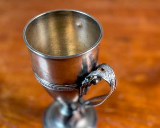 This lot features a 1873 birth commemorative sterling silver footed cup retailed by Ohio jeweler & silversmith, William Wilson McGrew (1833-1893). This silver cup was made to commemorate the birth of Nathaniel Foster Wilshire, son of George Wilshire who was a railroad and business tycoon. This cup measures, 5.25” H x 2.75” W x 4” D with a total approx. weight of 176.61 grams. Maker marks present underneath as shown in photos.