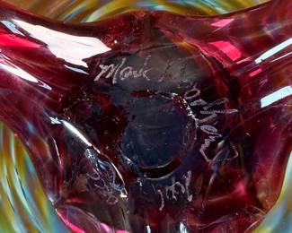 This lot features a stunning studio made footed glass bowl by listed artist, Mark Woodham. Signed and dated underneath and was made during Woodham’s time creating works at the One Eared Cow Glass Studio. This bowl measures, 5” H x 9” W x 9” D and is in excellent condition.