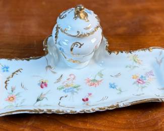 This lot features a collection of inkwells and accessories. One appears to be handmade out of wood and signed underneath by John R Craighead.