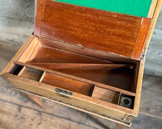 This lot features an incredible 19th century Italian travel desk on a wooden stand. The travel desk is removable and features numerous drawers and compartments inside. This piece measures (on the stand), 26” H x 20” W x 11” D.