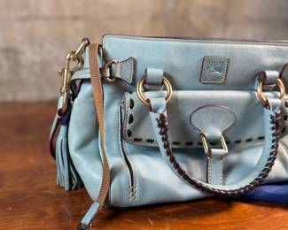 This lot features a Dooney & Bourke Florentine Satchel bag in blue Italian leather. This Dooney & Bourke comes with the original carry case as shown in photos and is in excellent condition.