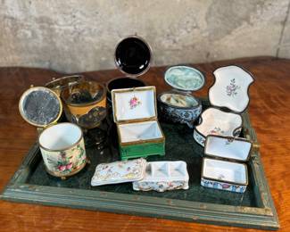 This lot features a large collection of antique trinket boxes that are primarily porcelain. Many of them contain maker marks and are held on a vintage green tray that is included.