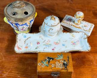 This lot features a collection of inkwells and accessories. One appears to be handmade out of wood and signed underneath by John R Craighead.