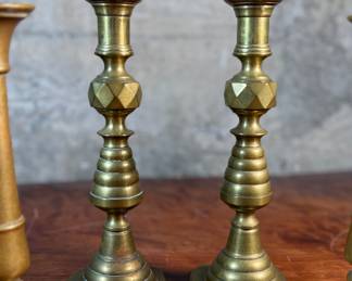 This lot features a collection of six (6) antique brass candlesticks. Three matching pairs with the tallest measuring, 9.5” H.