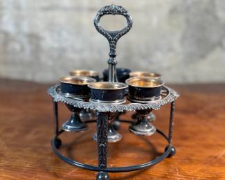 This lot features an antique silver-plated Victorian egg cruet set with six egg cups. This cruet measures, 9” H x 7.5” W x 7.5” D.