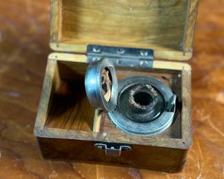 This lot features a collection of inkwells and accessories. One appears to be handmade out of wood and signed underneath by John R Craighead.