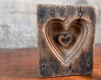 This lot features an antique wooden heart mold and a copper heart!